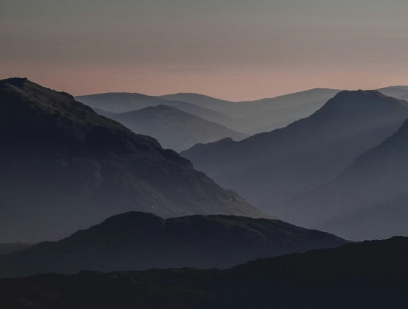 Mountains covered with mist that fade into the background.